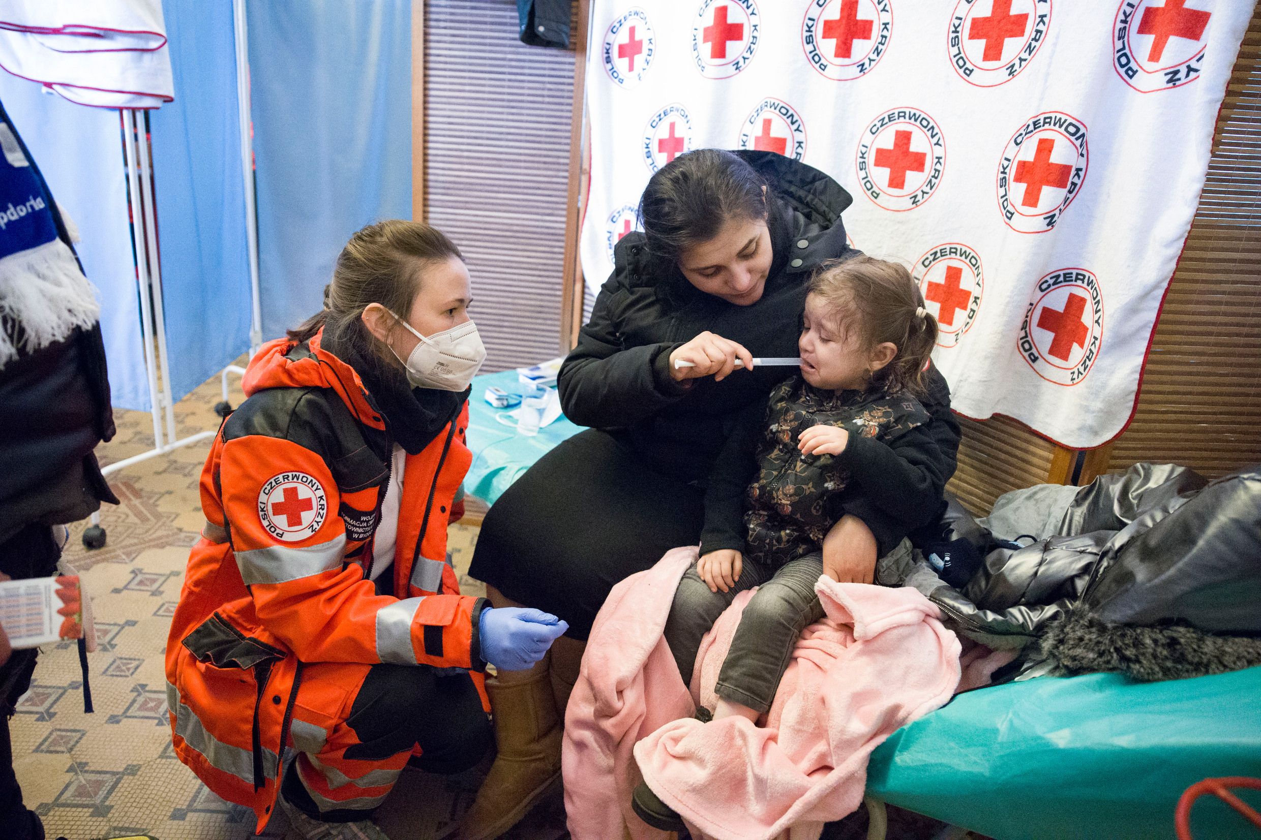Bewaffneter Konflikt in der Ukraine: Geflüchtete Frau und ihr Kind bei der Ankunft am Bahnhof von Przemysl / Polen. Das Polnische Rote Kreuz hat dort eine Station für die medizinische Erstversorgung eingerichtet.